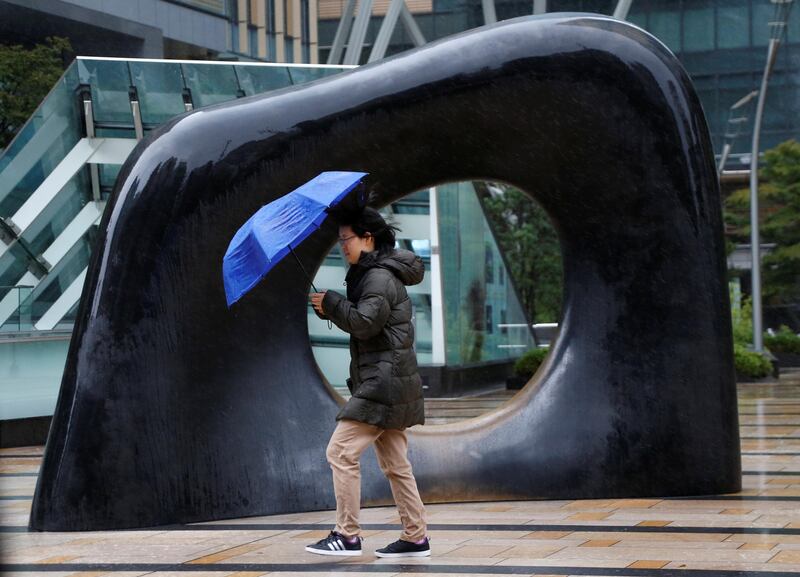 A woman struggles against a heavy rain and wind as Typhoon Lan approaches Japan's mainland. Issei Kato / Reuters
