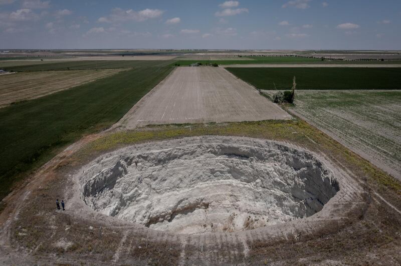 Geologists Fetullah Arik and Arif Delikana stand at the edge of a massive sinkhole in a field in Karapinar. While Konya produces more than 2.5 million tonnes of grain a year, officials predict this will fall 5.5 per cent in 2021.