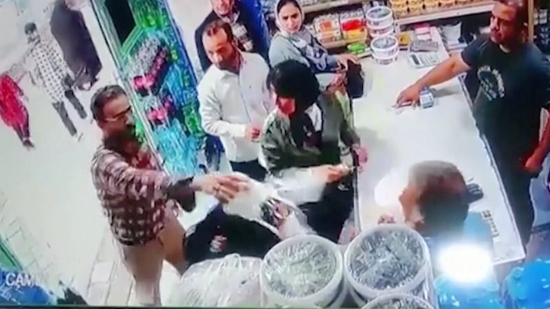 A screen grab from a Reuters video shows a man in Iran throwing yogurt on two women for not covering their hair.