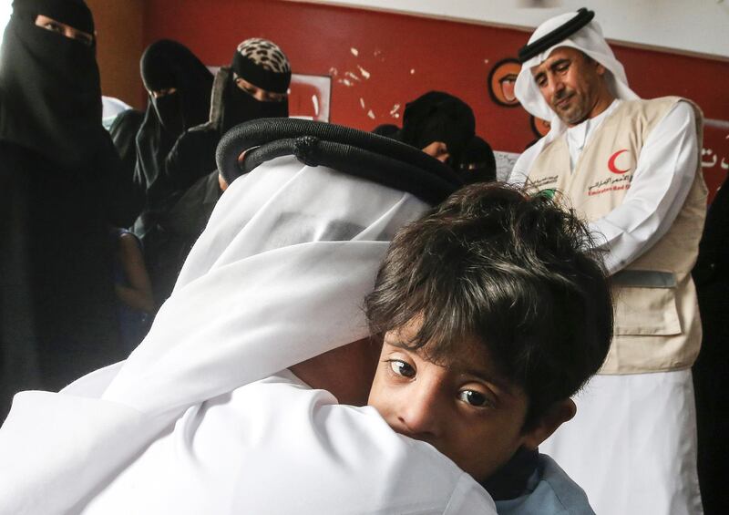The UAE's Humanitarian Operations Director for Yemen, Saeed Al Kaabi, centre, embracing a child at the premises of A Hayat Association for Early Intervention for Children with Special Needs, supervised by the UAE Red Crescent, in Aden. AFP