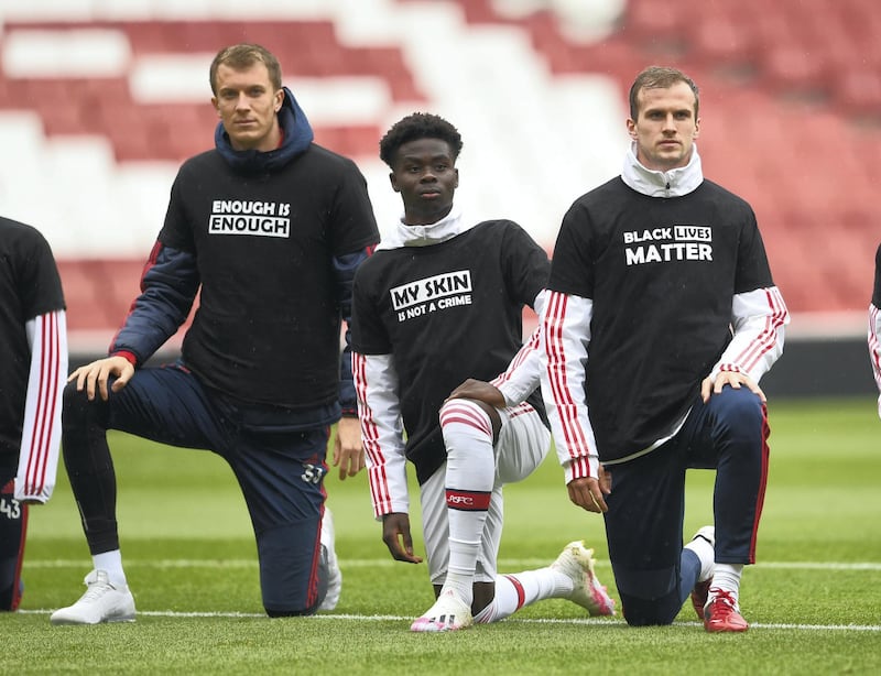 LONDON, ENGLAND - JUNE 10: Matt Macey, Bukayo Saka and Rob Holding of Arsenal take a knee in support of Black Lives Matter before the friendly match between Arsenal and Brentford at Emirates Stadium on June 10, 2020 in London, England. (Photo by David Price/Arsenal FC via Getty Images)