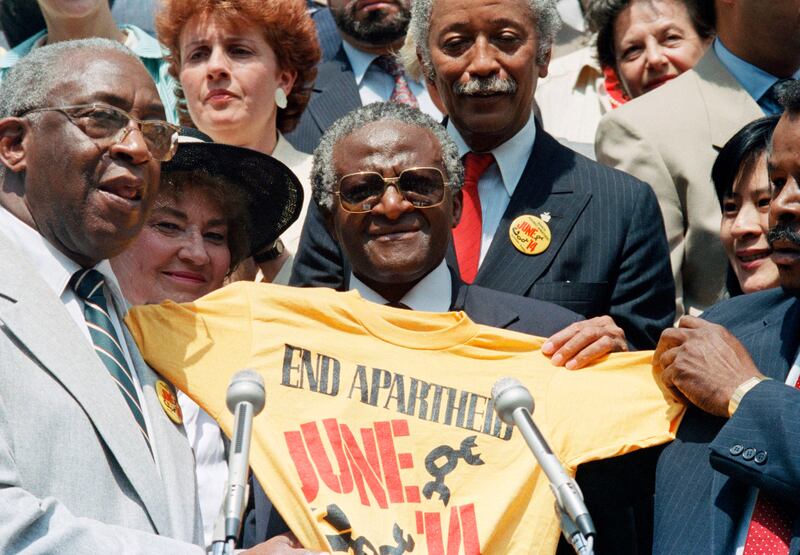 Tutu displays an "End Apartheid" T-shirt at New York's City Hall in 1986. AP