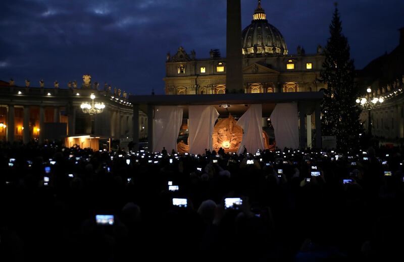 People take pictures of the Nativity scene and Christmas Tree that were officially unveiled in St Peter's Square at the Vatican.  The Nativity scene is made of sand and sculpted by an international set of artists. About 700 tons of sand have been shipped to St. Peter's Square for the sculpture, which are the centerpiece of the Vatican's Christmastime decorations along with a giant tree. AP