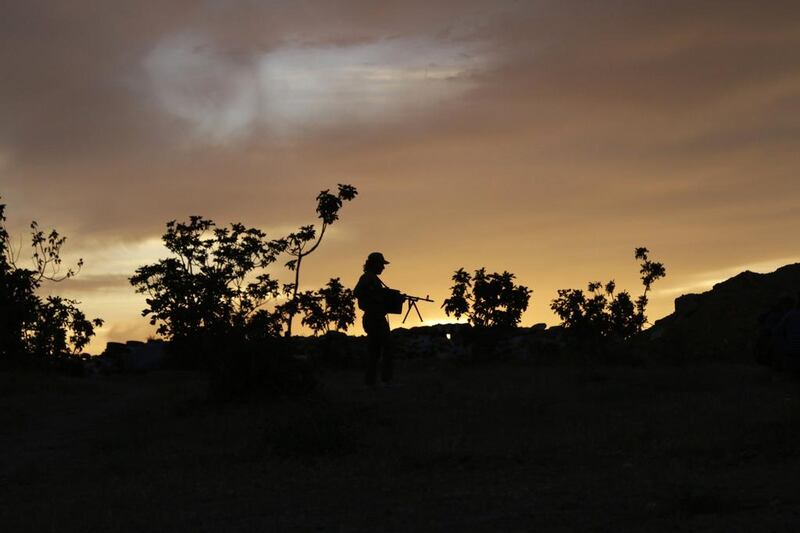 A Free Syrian Army fighter walks as he holds his weapon in Wadi al-Deif military camp in Idlib province. Khalil Ashawi / Reuters