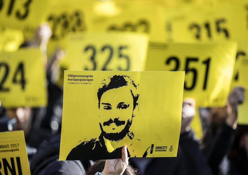 People hold up pictures of Giulio Regeni and reading in Italian ''365 days without Giulio Regeni, Truth for Giulio Regeni'' as they attend a march in memory of the the 28-year-old researcher who was abducted on a Cairo street on Jan. 25, 2016, at the Rome Sapienza University, Wednesday, Jan. 25, 2017.  (Massimo Percossi/ANSA via AP)