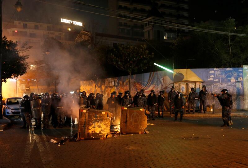 Riot police officers stand near burning garbage bins during protests against the economic crisis in Beirut, Lebanon.  Reuters