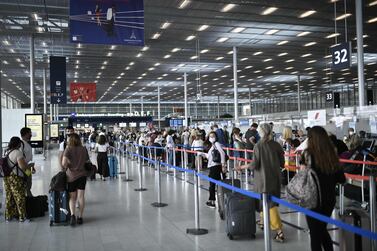 Travellers, wearing protective face masks, line up at Orly Airport during a major weekend of the French summer holidays in August. The International Air Transport Association is working on a mobile app to show travellers are free of Covid-19. AFP 