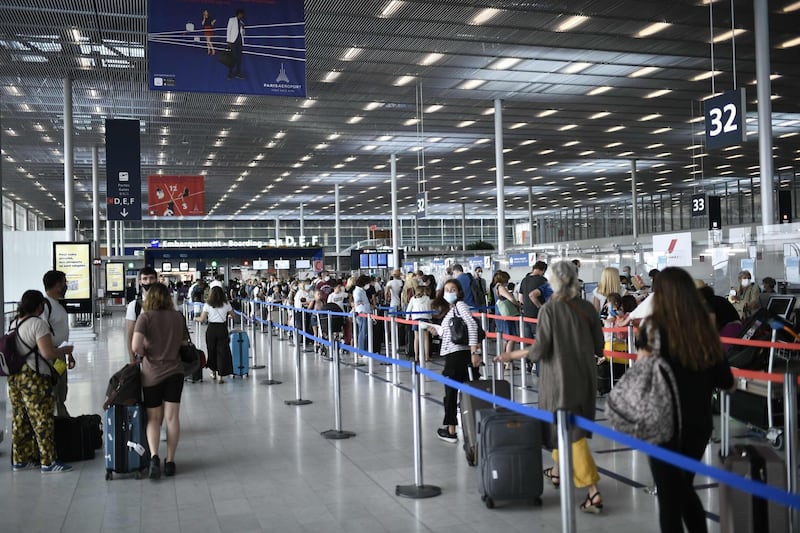 (FILES) In this file photo taken on August 1, 2020, Travelers, wearing protective face masks, line up at the Orly Airport, south of Paris during a major weekend of the French summer holidays. Airlines need up to another $80 billion to survive, the head of the industry's trade association told a French daily on November 20, 2020, as many countries tighten restrictions to confront another wave of coronavirus infections. "For the coming months the industry is estimated to need $70-$80 billion in additional aid," the head of the International Air Transport Association (IATA) Alexandre de Juniac told La Tribune. "Otherwise they won't survive." / AFP / STEPHANE DE SAKUTIN
