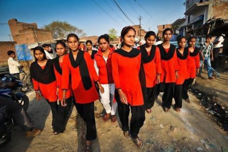 Young women from the Red Brigade walk through the Midiyav slum in the city of Lucknow. Their leader, Usha Vishwakarma, 25, is in white. Phot by Gethin Chamberlain for The National