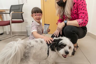 Hind Algaith, 6, from Kent College Dubai having a fun time with Ziggy the well-being dog. Antonie Robertson / The National
