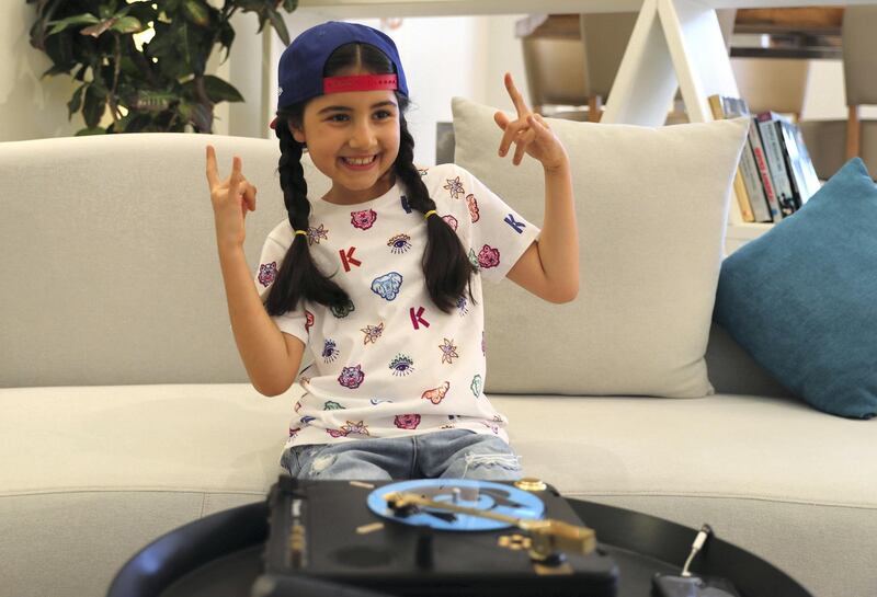 Michelle Rasul flashes a rockstar sign in the lobby of her apartment building in Dubai, United Arab Emirates, Sunday, May 9, 2021. Rasul, a 9-year-old girl from Azerbaijan who lives in Dubai, is scratching her way to the top as a DJ after competing in the DMC World DJ Championship. (AP Photo/Kamran Jebreili)