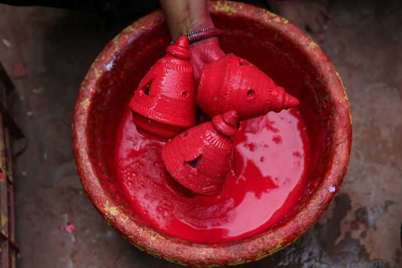 An Indian woman paints an earthen lamp in Dharavi, Mumbai. EPA