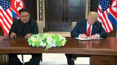 In this image made from video provided by Host Broadcaster Mediacorp Pte Ltd,, U.S. President Donald Trump, right, signs an agreement with North Korean leader Kim Jong Un after their meeting at Capella Hotel in Singapore, Tuesday, June 12, 2018. (Host Broadcaster Mediacorp Pte Ltd via AP)