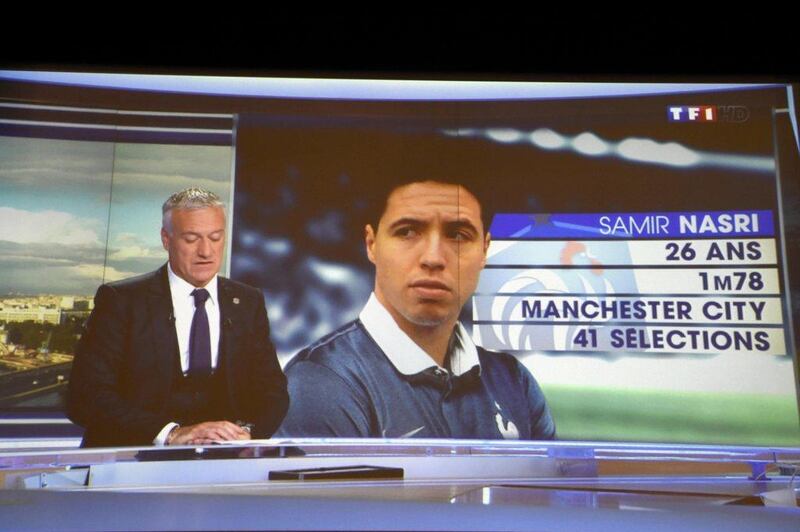 Didier Deschamps announces the 2014 World Cup France squad on French television Tuesday night. Samir Nasri, pictured on screen, was not included. Franck Fife / Reuters / May 13, 2014