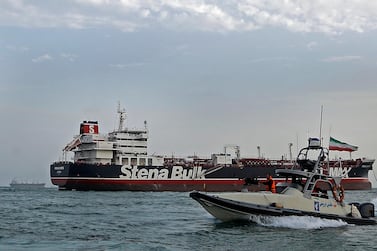 A speedboat of Iran's Revolutionary Guard passes the British-flagged oil tanker Stena Impero in Bandar Abbas port, where the ship has been detained since July. Mizan News Agency via AP