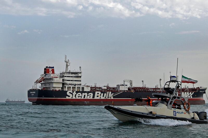 FILE - In this July 21, 2019, file photo, a speedboat of the Iran's Revolutionary Guard moves around a British-flagged oil tanker Stena Impero, which was seized on Friday by the Guard, in the Iranian port of Bandar Abbas. A ship-tracking website shows a British-flagged oil tanker held by Iran since July moving for the first time in weeks. The movement of the Stena Impero on Tuesday, Sept. 24,  comes after a government spokesman in Iran on Monday said legal proceedings against the vessel had concluded.(Hasan Shirvani/Mizan News Agency via AP, File)