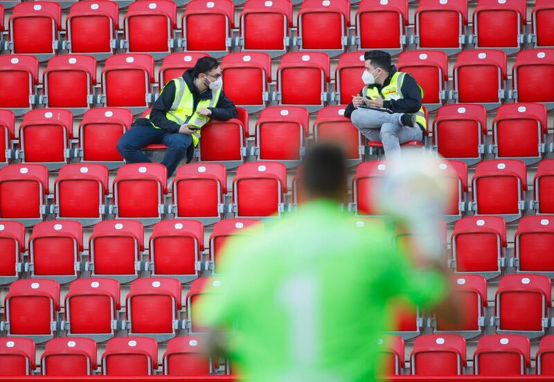 Stewards wearing protective face masks are seen in the stands. EPA