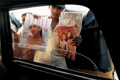 MUMBAI, INDIA - JANUARY 1997:  A young boy selling glossy gossip film magazines January 1997 in Mumbai, India. Stardust and Filmfare are two of the local film monthlies, reporting gossip on who's secretly seeing whom, which star is furious with which etc.  (Photo by Jonathan Torgovnik/Getty Images)
