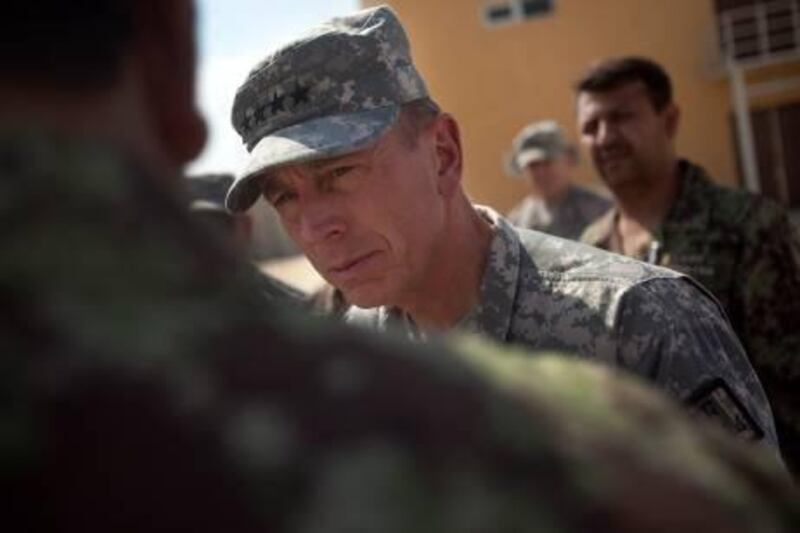 In this photo reviewed by the U.S. military, the top American commander in Afghanistan Gen. David Petraeus speaks with Afghan military personnel during a tour of the U.S. run Parwan detention facility near Bagram north of Kabul, Afghanistan on Monday Sept. 27, 2010. The U.S. military opened the new prison named after the surrounding Parwan province in November to replace the original facility in an effort to improve living conditions and reintegration programs. (AP Photo/David Guttenfelder)