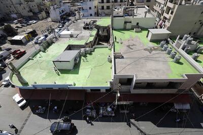 Lebanese painters take part in a project, that aims to draw the word Peace in Arabic across 85 rooftops, in Tripoli's Syria street which separetes the Sunni neighbourhood of Bab al-Tabbaneh from the Alawite neighbourhood of Jabal Mohsen, in Tripoli on September 28, 2017.
The project has been three years in the making, with the artists, 34-year-old twins Mohamed and Omar Kabbani, researching and rejecting multiple locations in their native Lebanon before settling on Tripoli. / AFP PHOTO / Joseph EID