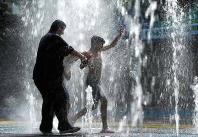 People cool off in a water fountain on a hot summer day in Tbilisi, Georgia, July 2, 2018. REUTERS/David Mdzinarishvili