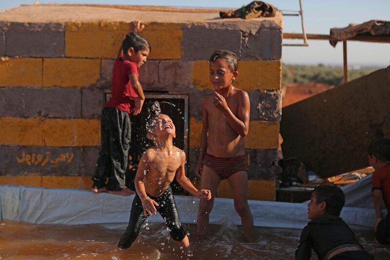 Children play in a makeshift pool in the back of a pick-up truck in Killi, where the temperature has regularly exceeded 40°C in the past few days.  