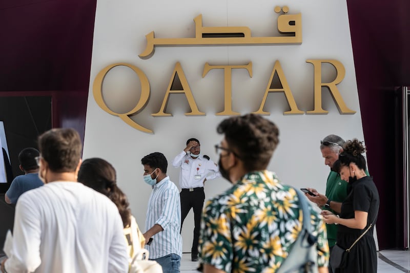 A guard wipes the sweat from his brow as visitors enter and exit the Qatar Pavilion. Antonie Robertson / The National