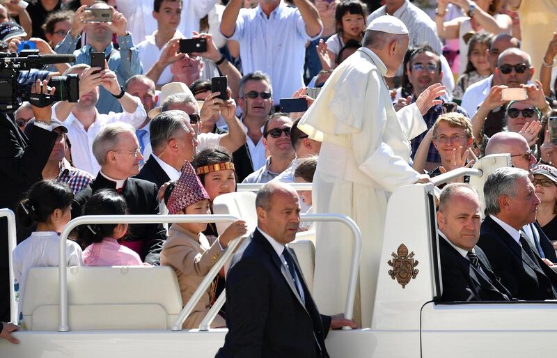 Pope Francis, centre, with four children on the popemobile, waves to the faithful as he  arrives to lead the weekly general audience in Saint Peters Square, Vatican City, on June 27, 2018. Ettore Ferrari / EPA