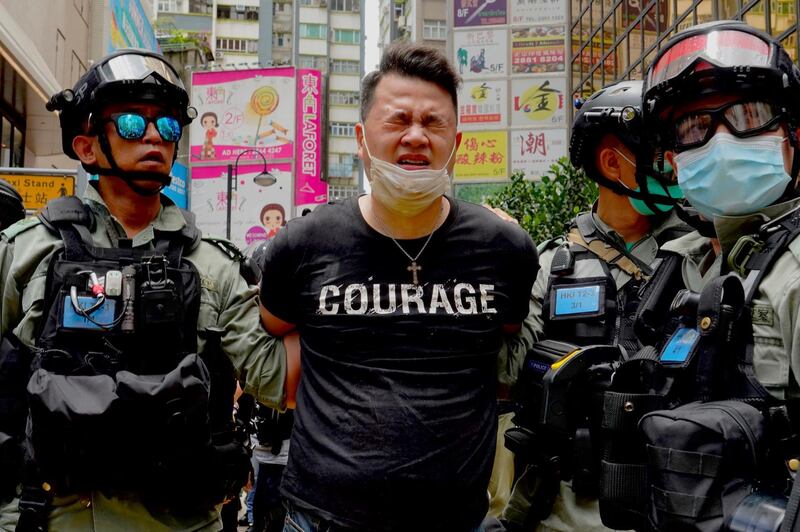 Police detain a protester after being sprayed with pepper spray during a protest in Causeway Bay before the annual handover march in Hong Kong. AP Photo