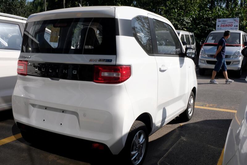 A man walks past a Wuling Hongguang MINI EV (C) at a SAIC-GM-Wuling dealership in Beijing, China, September 20, 2020. Picture taken September 20, 2020. REUTERS/Yilei Sun