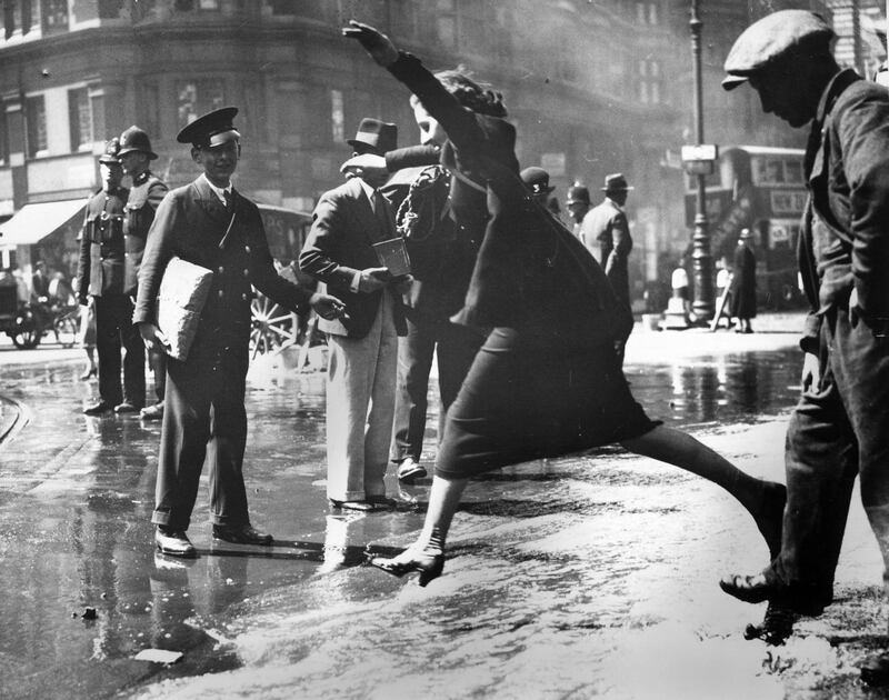 A pedestrian negotiating a burst water main in Theobald's Road, Bloomsbury, London, 16th June 1936. (Photo by George W. Hales/Fox Photos/Getty Images)