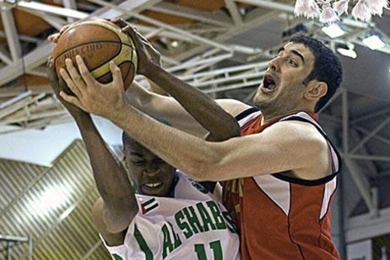 Rashed Naser of Al Shabab, left,  and Mohammed Sale of Al Rayyan fight for a rebound.