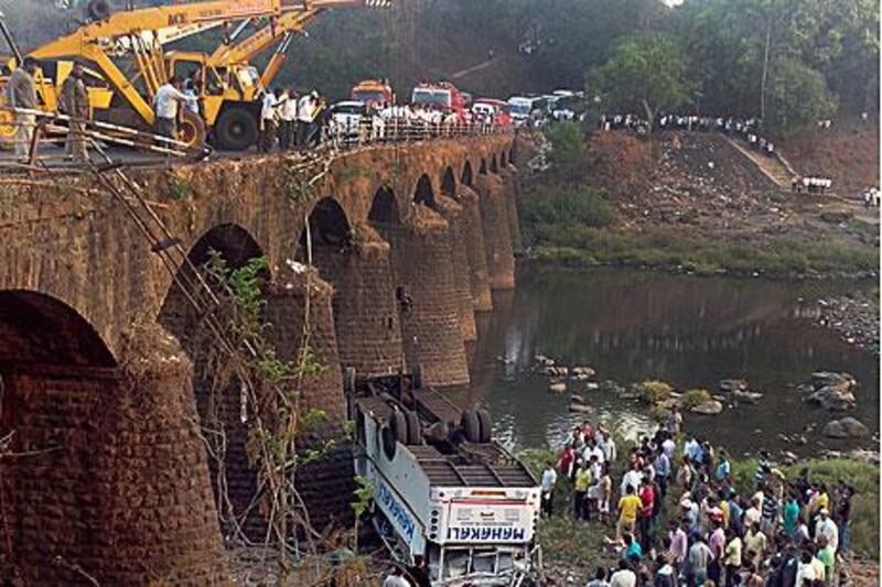 Rescuers assist injured travellers after at least 37 people were killed when a speeding bus crashed off a bridge in India.