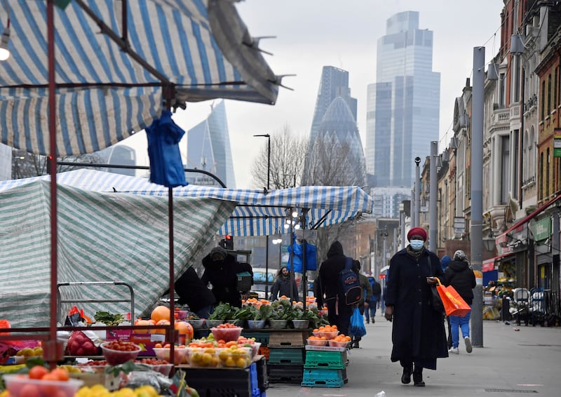A street market in London, with the skyscrapers of the CIty of London financial district in the background. The UK economy is 2.1 per cent smaller than it was in the final three months of 2019. Reuters
