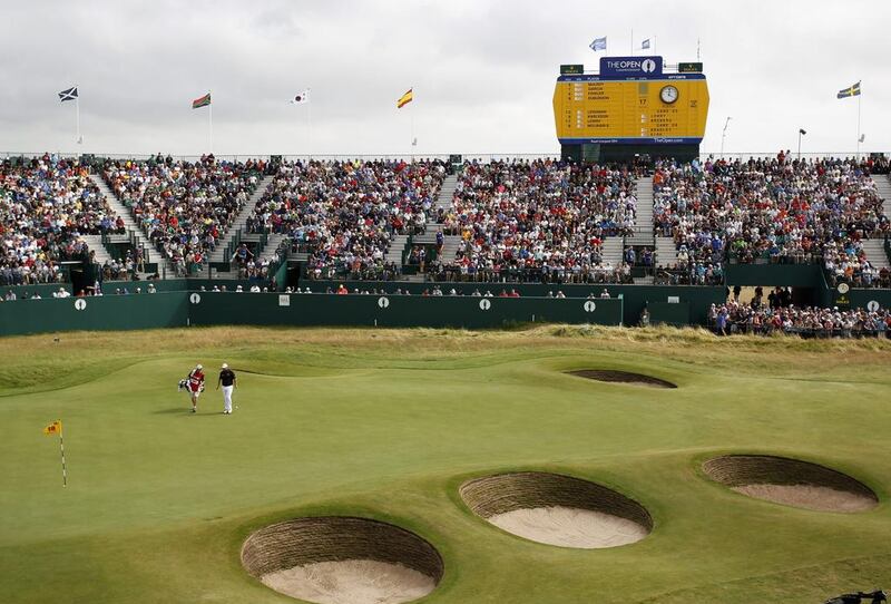 Shane Lowry walks to make a putt on the 18th green with his caddie Dermot Byrne during the final round of the British Open on Sunday. AP Photo