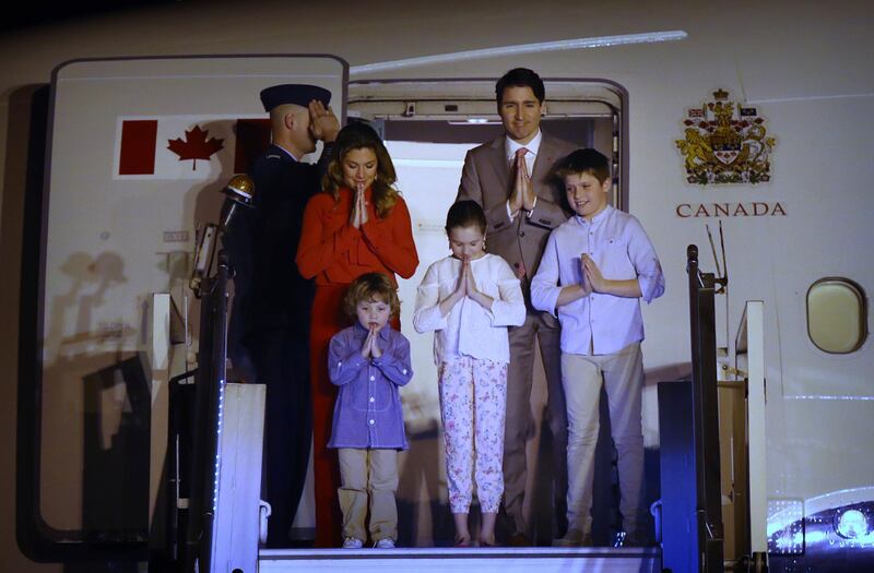 The Trudeaus greet with a traditional Indian "namaste" as they step out of the aircraft upon their arrival at the Palam Air Force Station in New Delhi. Manish Swarup / AP Photo