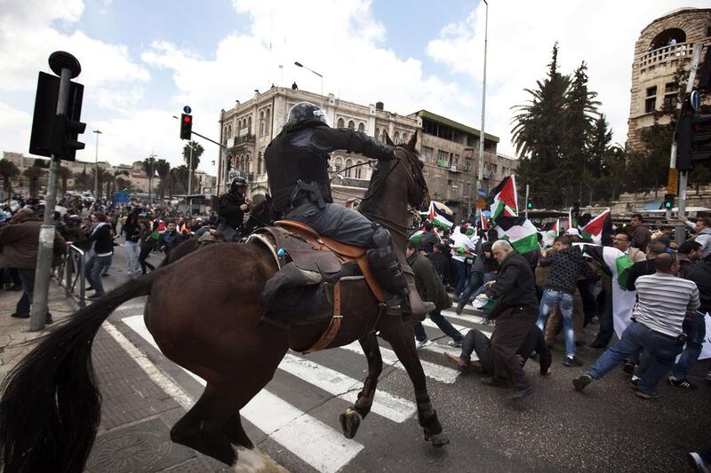 An Israeli mounted policeman disperses hundreds of Palestinian protesters during a demonstration marking Land Day in east Jerusalem. Menahem Kahana / AFP Photo

