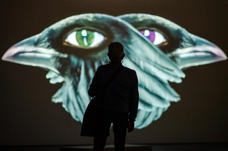 A visitor stands in front of a video installation of the artwork 'The Demon's Brain' by Polish artist Agnieszka Polska (not in the picture) at the 'Hamburger Bahnhof' exhibition hall in Berlin, Germany. EPA