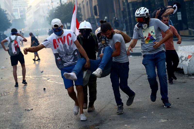 Demonstrators carry an injured man during anti-government protests that have been ignited by a massive explosion in Beirut, Lebanon, August 10, 2020. REUTERS/Hannah McKay     TPX IMAGES OF THE DAY