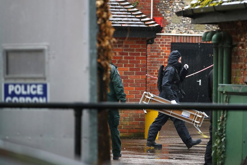Police officers in black protective suits arrive with new equipment in the cordoned off area around The Mill public house, which had been visited by Sergei Skripal, in Salisbury, Britain, April 4, 2018. REUTERS/Hannah McKay