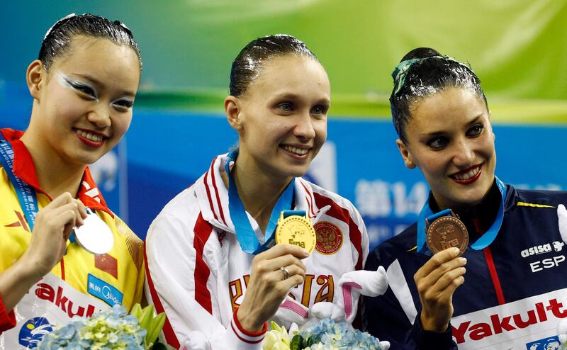 The Russian swimmer Natalia Ishchenko holds her gold medal after winning the synchronised swimming solo technical, next to Huang Xuenchen from China, left,  and Andrea Fuentes from Spain. 

Carlos Barria / Reuters