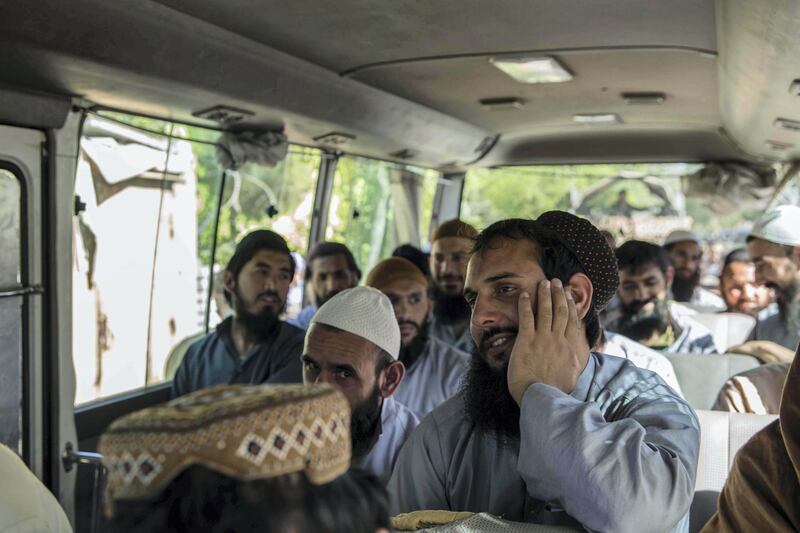 Prisoners sit in a bus taking them to Kabul, from where they are free to take public transportation home. Stefanie Glinski for The National