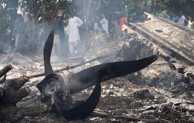 Civilians stand near the burning wreckage of the plane. Reuters