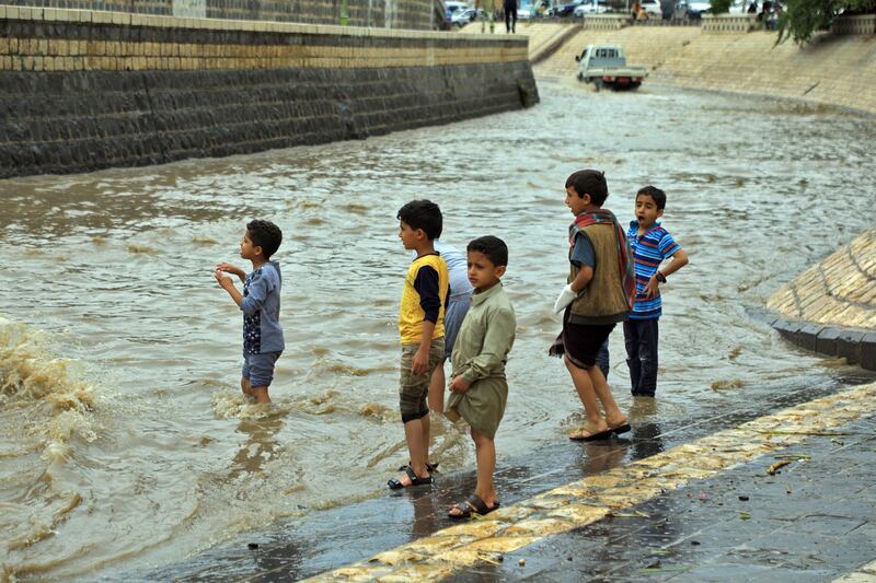 Children gather, undeterred by floods in the city. AFP