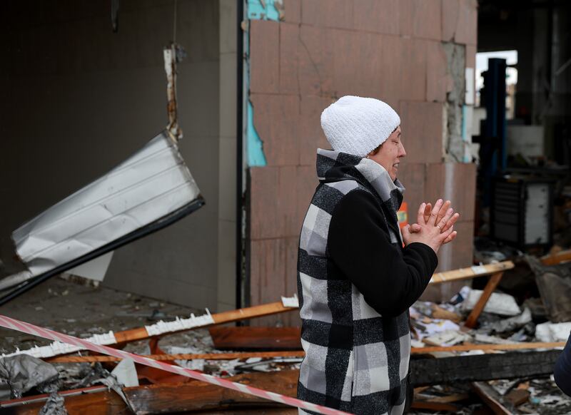 A woman stands amid the destruction caused when a civilian building was hit by a Russian missile in Lviv, western Ukraine. Getty Images