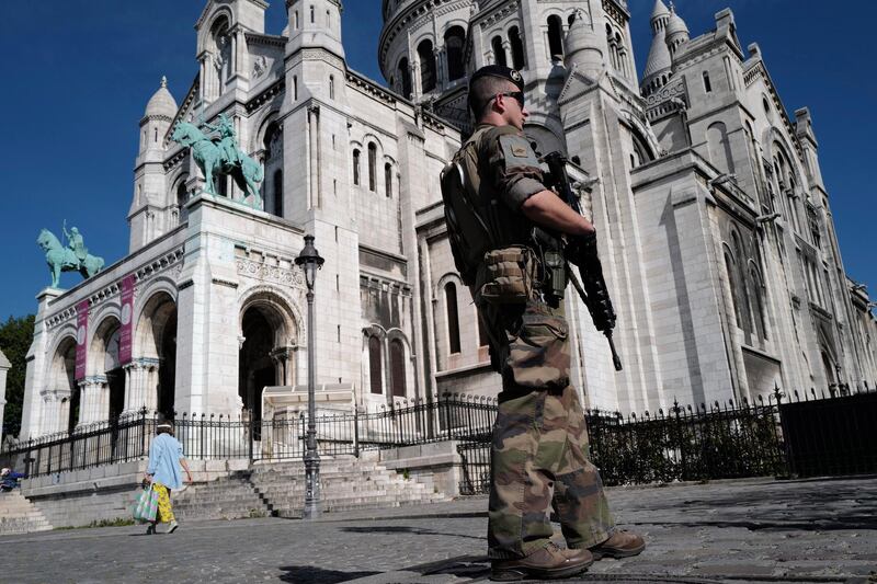 A soldier of French antiterrorist plan "Vigipirate Mission" patrols front of Sacre Coeur Basilica in the Montmartre district in Paris, France. AP Photo