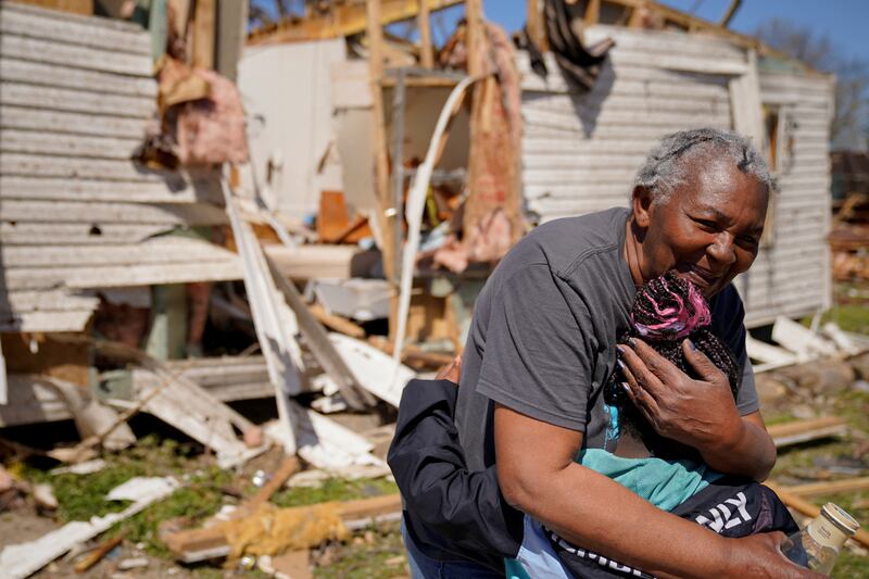 Ester Johnson-El, 62, embraces her great-granddaughter She-Keelie, six, beside the wreckage of her home after a tornado hit the Arkansas town of Wynne. Reuters