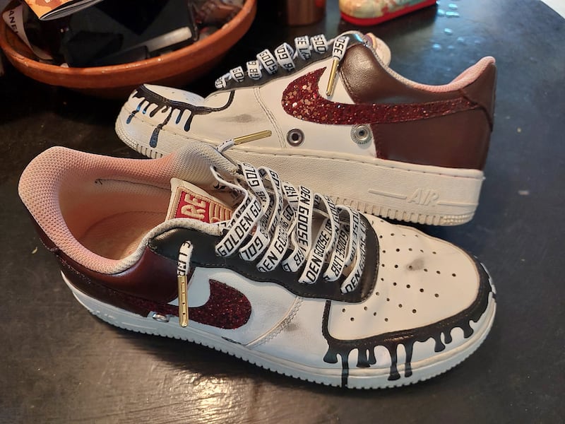 The trainers now sport shades of burgundy and black, a silver leather tongue, Golden Goose-branded laces and distressed detailing. Sarah Maisey / The National