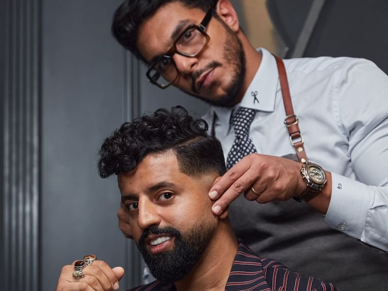 Carlos Gamal, the owner and founder of CG Barbershop in Dubai, with a customer. Photo: CG Barbershop