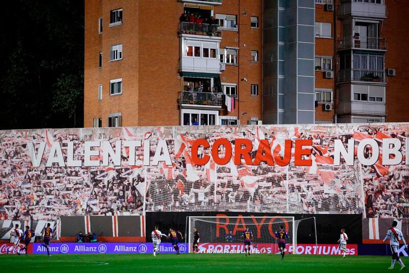 Residents of a building adjacent to the Vallecas stadium stand on their balconies to watch the match. AFP
